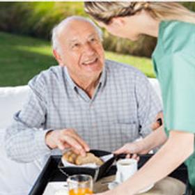 Staff serving a meal to a resident